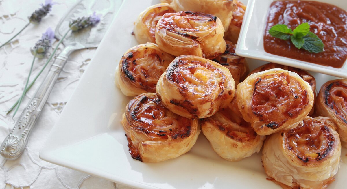 Mehrere Blätterteig-Schnecken mit Hawaii-Füllung auf einem weißen Teller. 
