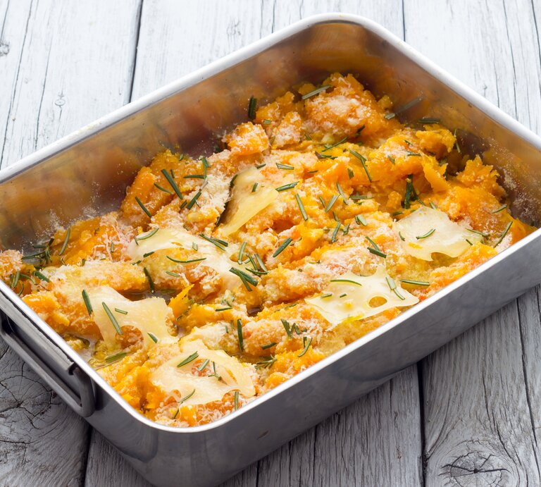 Blecherne Auflaufform gefüllt mit Kürbisauflauf und Parmesan. | © iStock/ fpwing