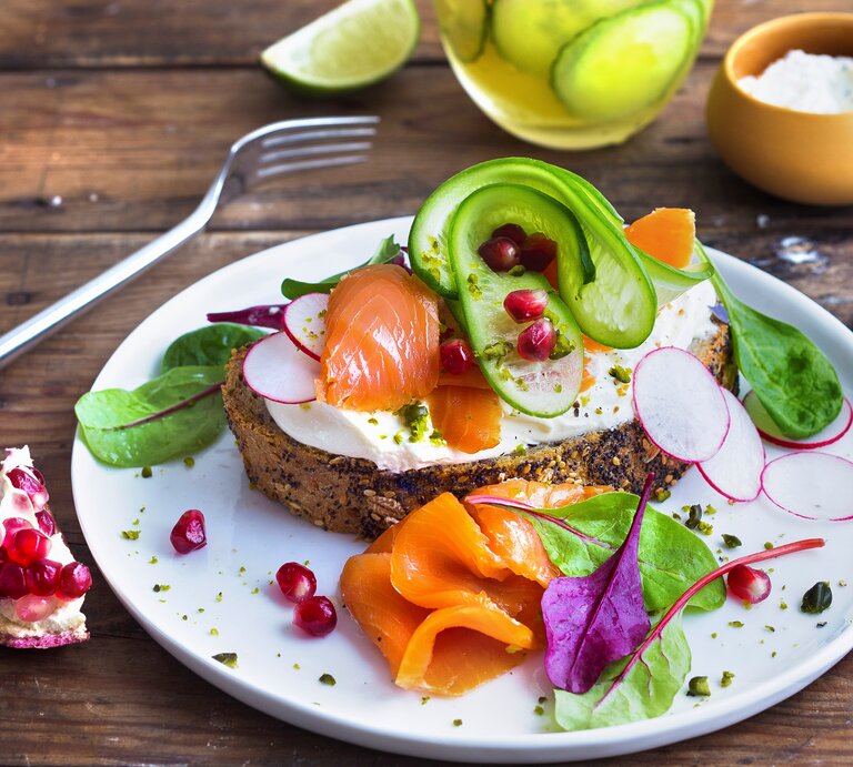Draufsicht, schräg: Ein weißer Teller mit einer Low-Carb-Stulle mit Lachs und Pistazien. | © StockFood / Leoni, Ira