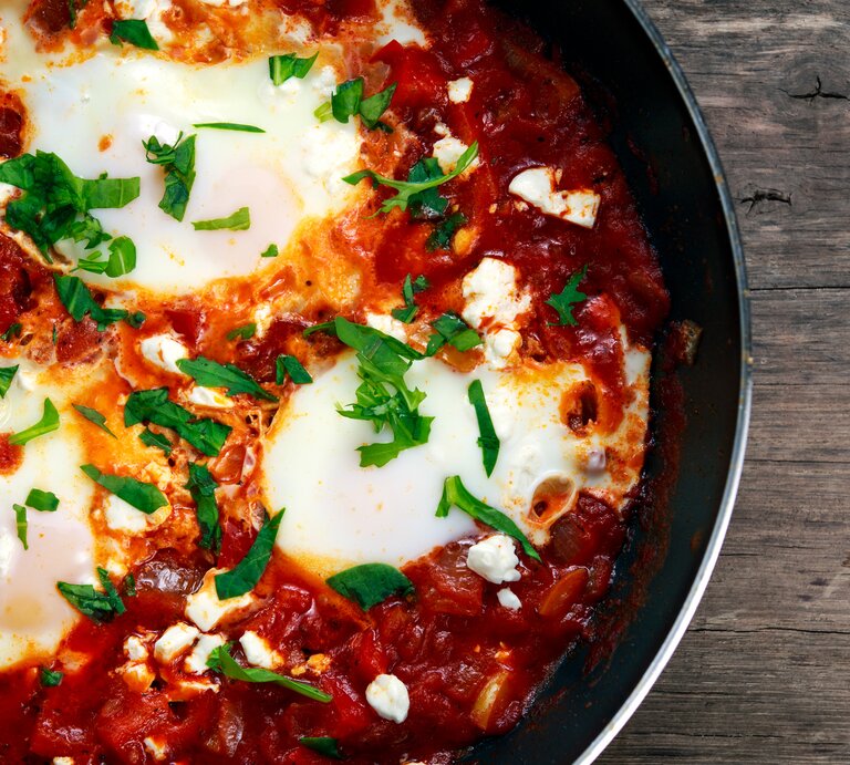 Draufsicht auf eine runde Pfanne gefüllt mit Gemüse und Ei, auch Shakshuka genannt, | © iStock/DronG