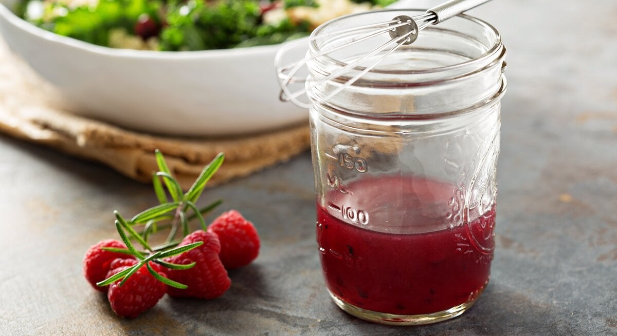 Seitliche Ansicht auf ein Glas mit Himbeer-Vinaigrette. | © iStock/VeselovaElena