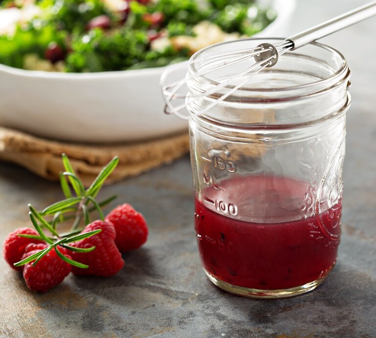 Seitliche Ansicht auf ein Glas mit Himbeer-Vinaigrette. | © iStock/VeselovaElena