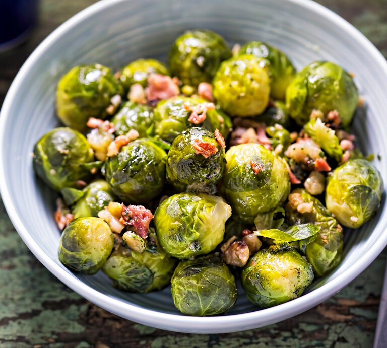 Helle Schüssel gefüllt mit gebratenem Rosenkohl mit Speck. | © iStock/ Bartosz Luczak