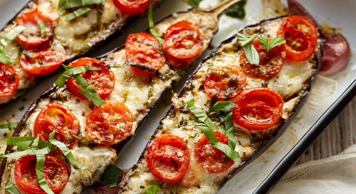 gebackene Auberginenscheiben belegt mit Tomate, Käse und Basilikum.