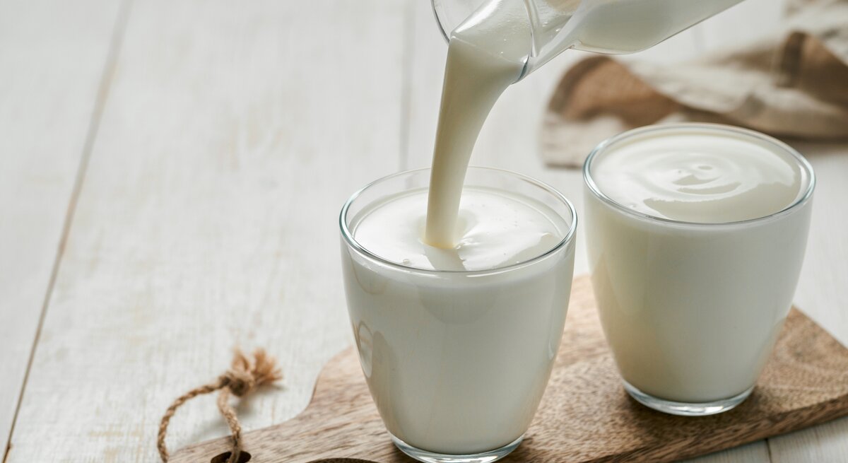 Buttermilch wird in ein Glas gegossen. 