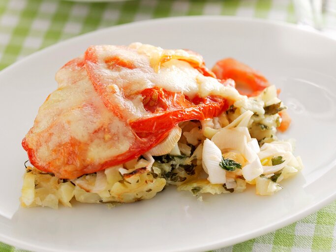 Eierlasagne auf einem weißen Teller. Das Ganze auf einer weiß-grün karierten Tischdecke | © StockFood/Benjamins, Sven