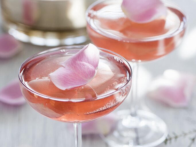 Zwei Champagnergläser mit rosa Sektgelee, in denen essbare Rosenblätter eingeschlossen sind. | © StockFood/Heinze, Winfried