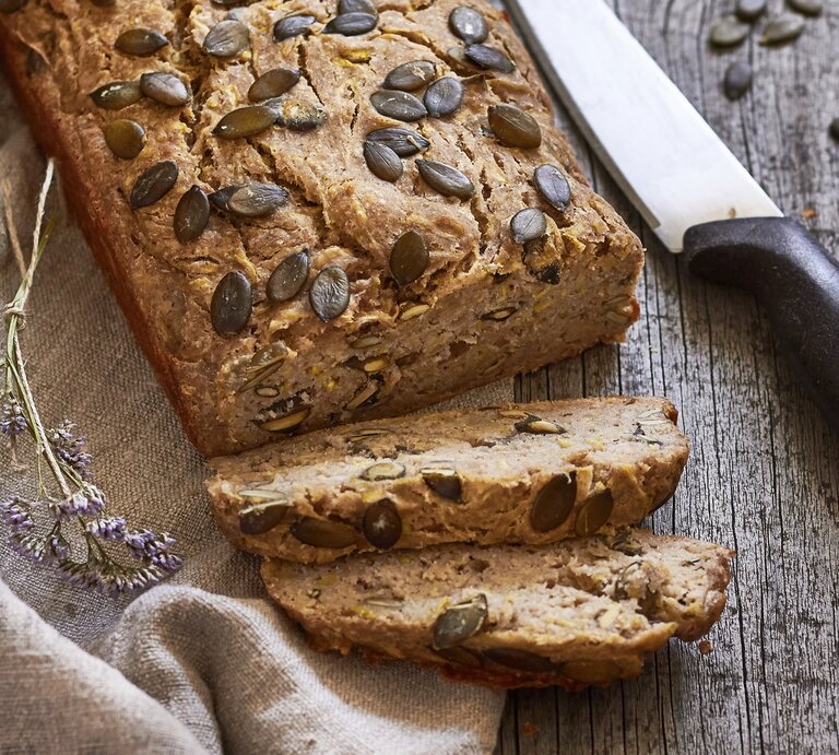 Ein angeschnittenes Zucchinibrot mit Banane. Daneben liegt ein großes Küchenmesser. | © StockFood / Krol, Helena