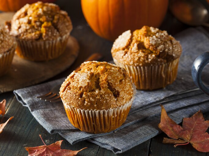 Zwei Kürbismuffins in herbstlichen Ambiente. | © iStock/bhofack2