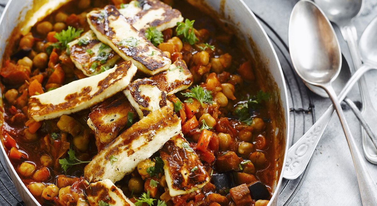 Auflaufform gefüllt mit einem Kichererbsen-Gulasch mit Halloumi.