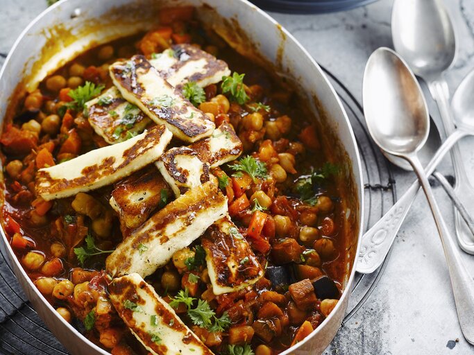 Auflaufform gefüllt mit einem Kichererbsen-Gulasch mit Halloumi. | © Stockfood/Photocuisine / Thys/Supperdelux
