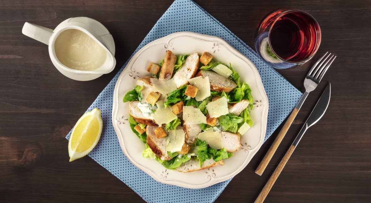 Draufsicht auf einen teller mit Salat, garniert mit hausgemachtem Caesar Dressing.