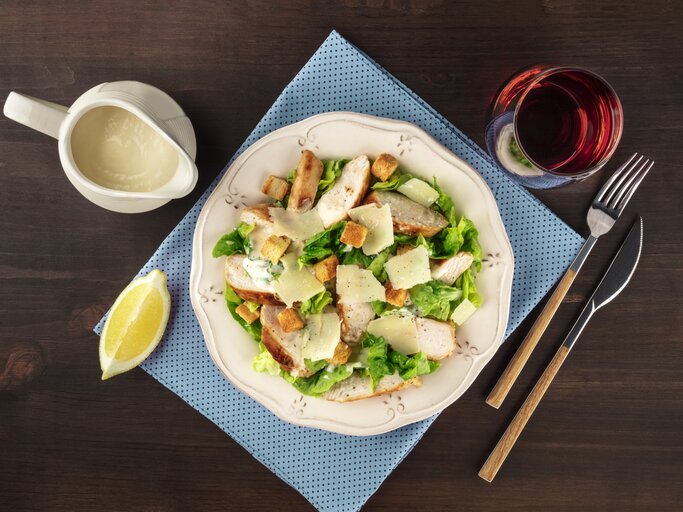 Draufsicht auf einen teller mit Salat, garniert mit hausgemachtem Caesar Dressing. | © iStock/Plateresca