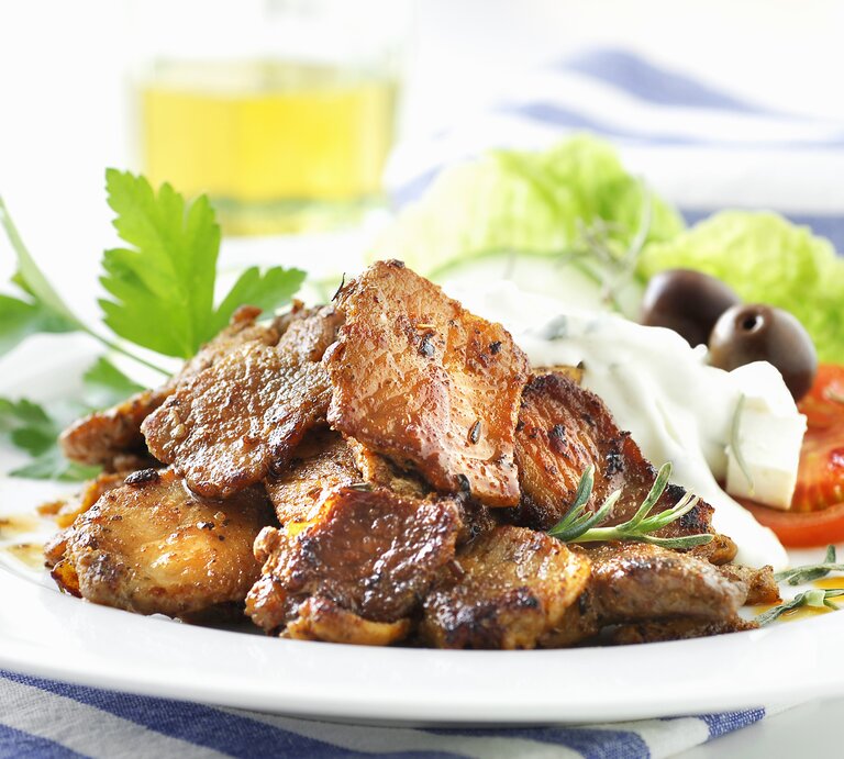 Weißer Teller, darauf angerichtet Gyros und Tzaziki. | © StockFood / Plewinski, Antje