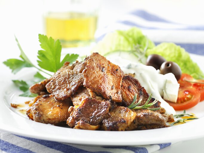 Weißer Teller, darauf angerichtet Gyros und Tzaziki. | © StockFood / Plewinski, Antje