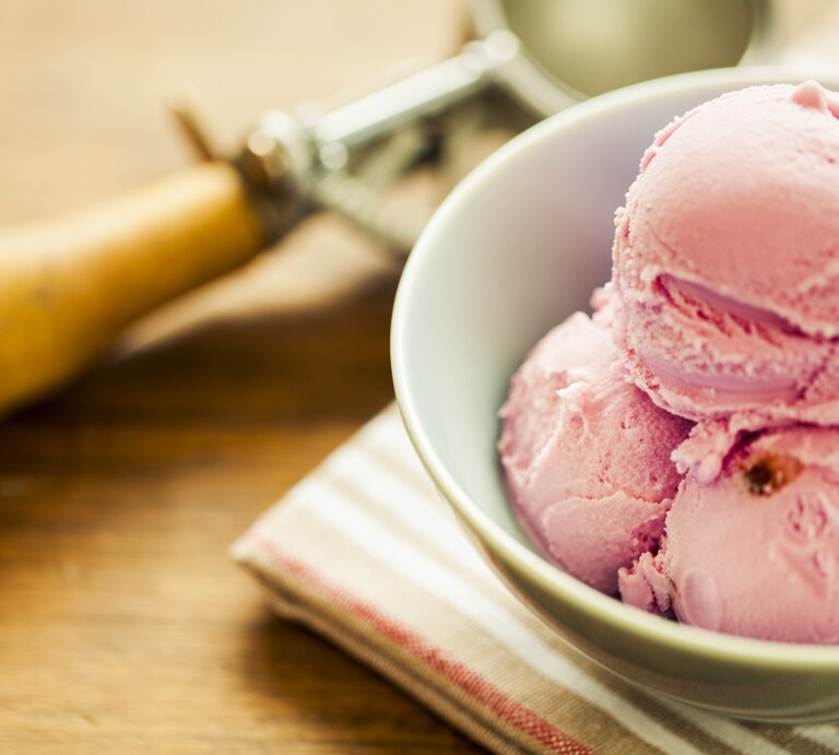 Mehrere Bällchen Erdbeer-Käsekuchen-Eis in einer weißen Schale.  | © iStock.com/MmeEmil