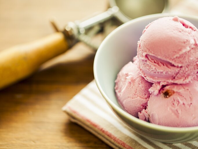 Mehrere Bällchen Erdbeer-Käsekuchen-Eis in einer weißen Schale.  | © iStock.com/MmeEmil