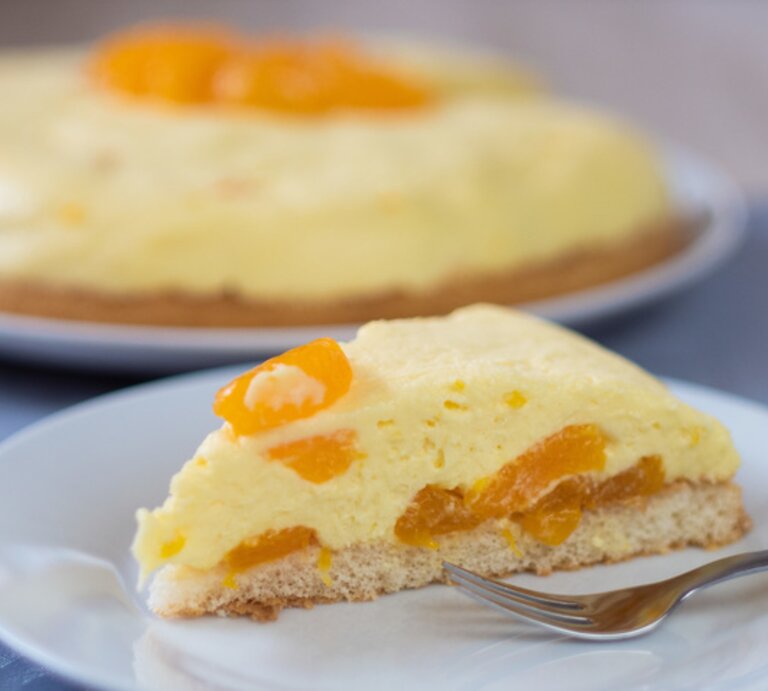 Ein angeschnittenes Stück Schüttelkuchen mit Mandarinen auf einem weißen Teller.  | © BILD der FRAU/Mayté Richter