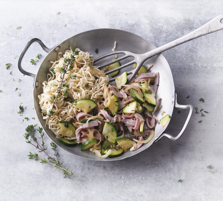 Ein silberner Wok mit dem Gericht auf einem grauen Steintisch direkt von oben fotografiert. | © StockFood / Gräfe & Unzer Verlag / Kramp + Gölling