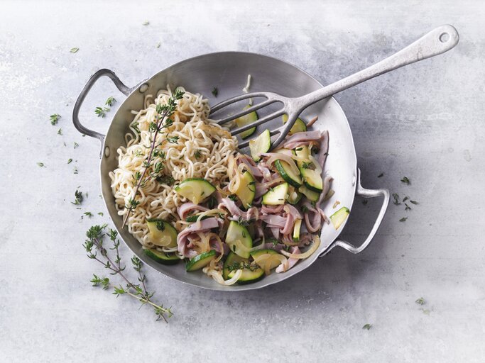 Ein silberner Wok mit dem Gericht auf einem grauen Steintisch direkt von oben fotografiert. | © StockFood / Gräfe & Unzer Verlag / Kramp + Gölling