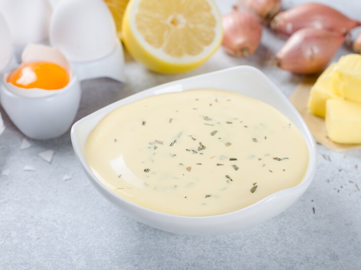 Sauce béarnaise in einer weißen Schale, daneben die klassischen Zutaten.  | © iStock/losinstantes
