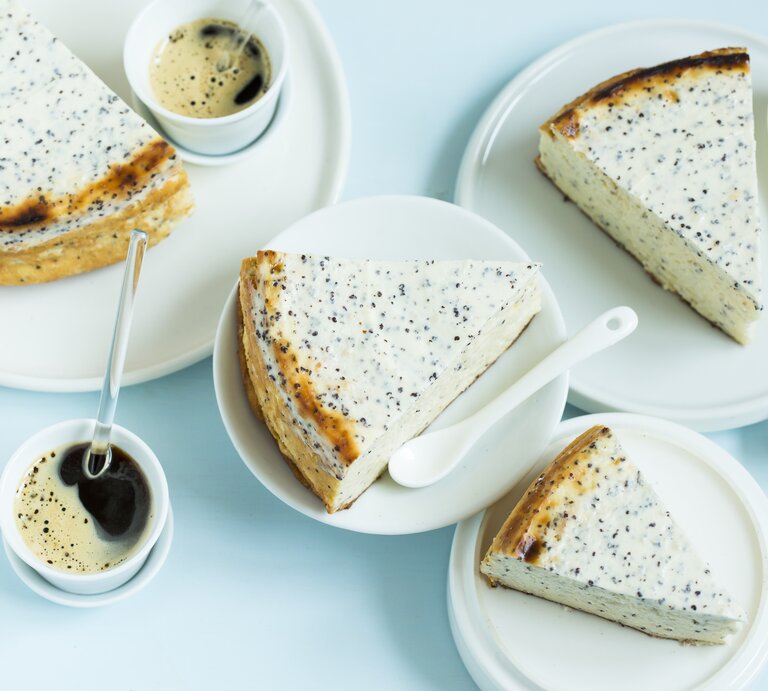 Mehrere Stücken vom Käsekuchen auf weißem Geschirr und einer hellblauen Tischdecke. Daneben noch Kaffee in kleinen Tassen. Alles direkt von oben fotografiert. | © StockFood / Gräfe & Unzer Verlag / D'Angelo, Vivi