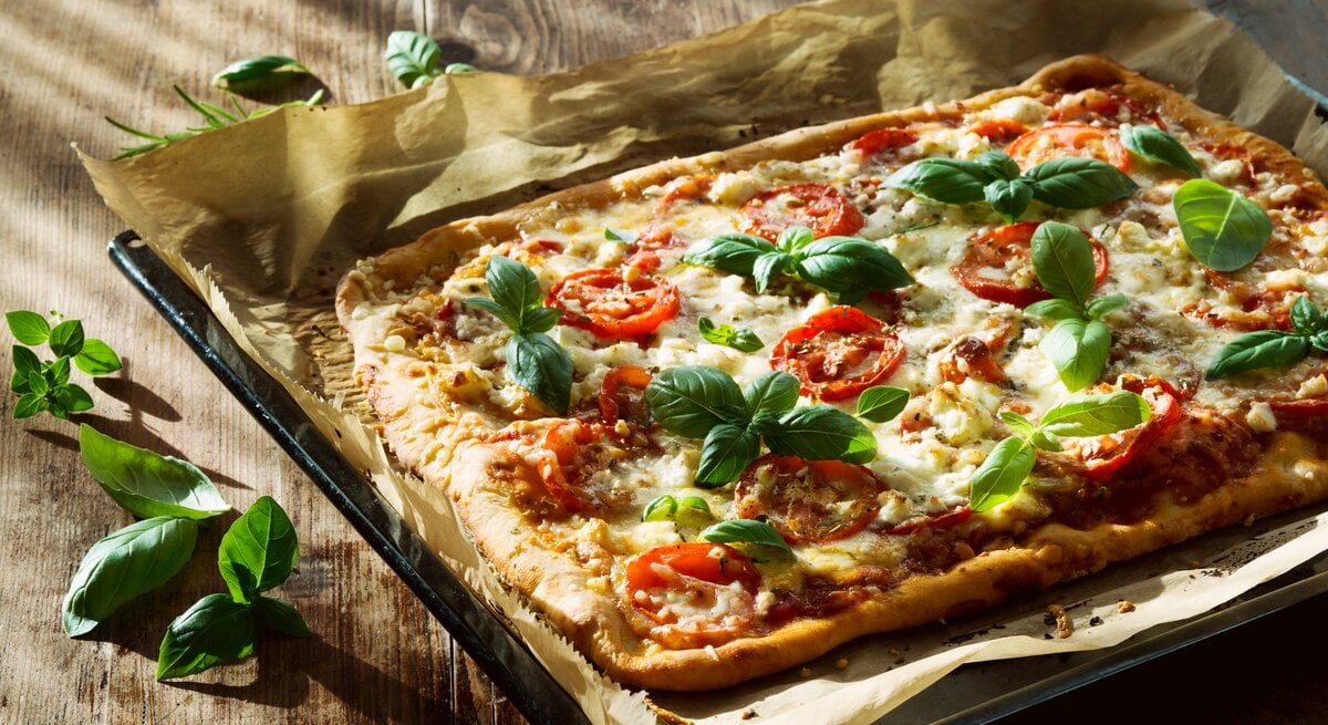 Ein Pizzablech belegt mit Pizza.