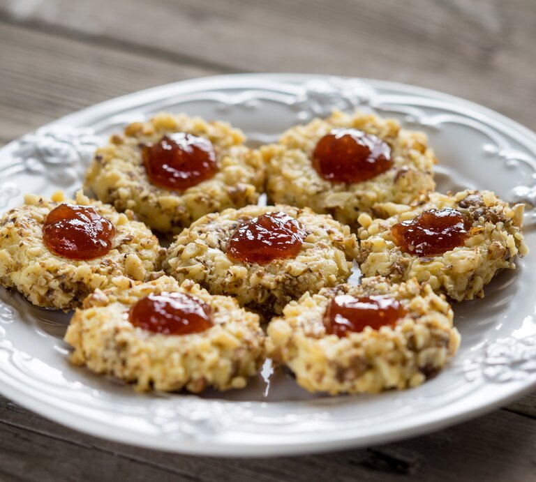 Mehrere Weihnachtsplätzchen "Husarenhüte" auf einem weißen, altmodischen Teller.  | © iStock / dr911