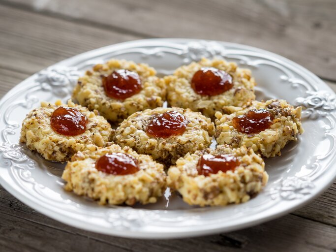 Mehrere Weihnachtsplätzchen "Husarenhüte" auf einem weißen, altmodischen Teller.  | © iStock / dr911