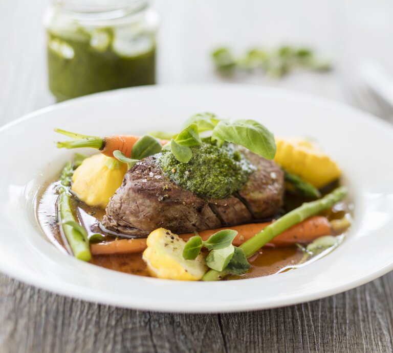 Das Rinderfilet auf einem weißen Teller mit reichlich Gemüse vor weißem Hintergrund. | © StockFood / StockFood / Wischnewski, Jan
