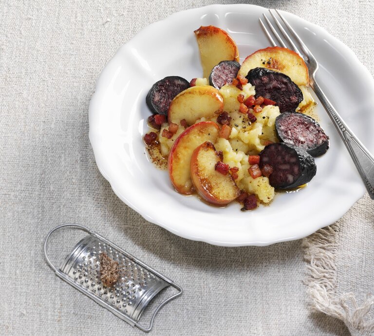 Himmel und Erde mit Kartoffeln, Äpfeln, Speck und Blutwurst / runder Teller / besteck / Nahaufnahme / Draufsicht | © StockFood / Newedel, Karl 