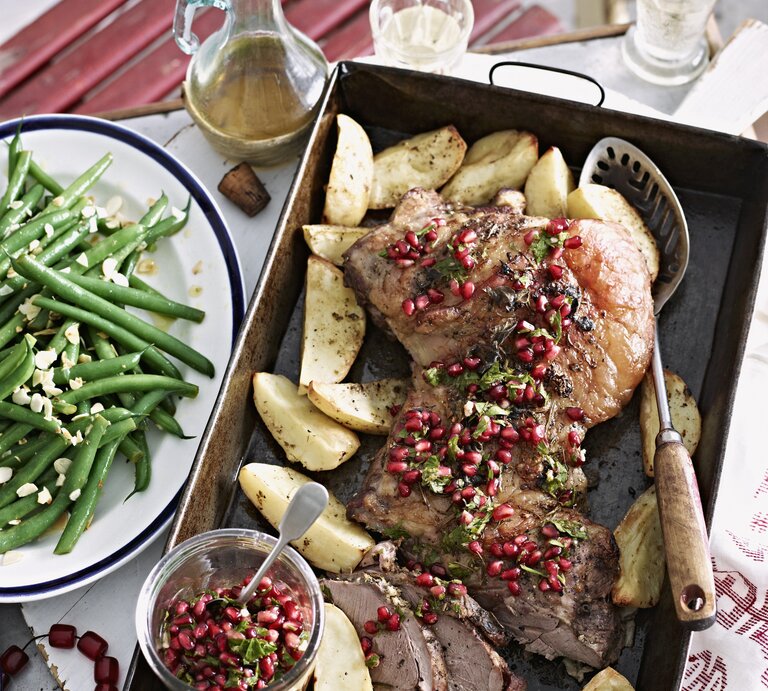 Lammbraten mit Granatapfelkernen und Gemüse. Alles auf einem Tisch arrangiert und von oben fotografiert. | © StockFood / People Pictures