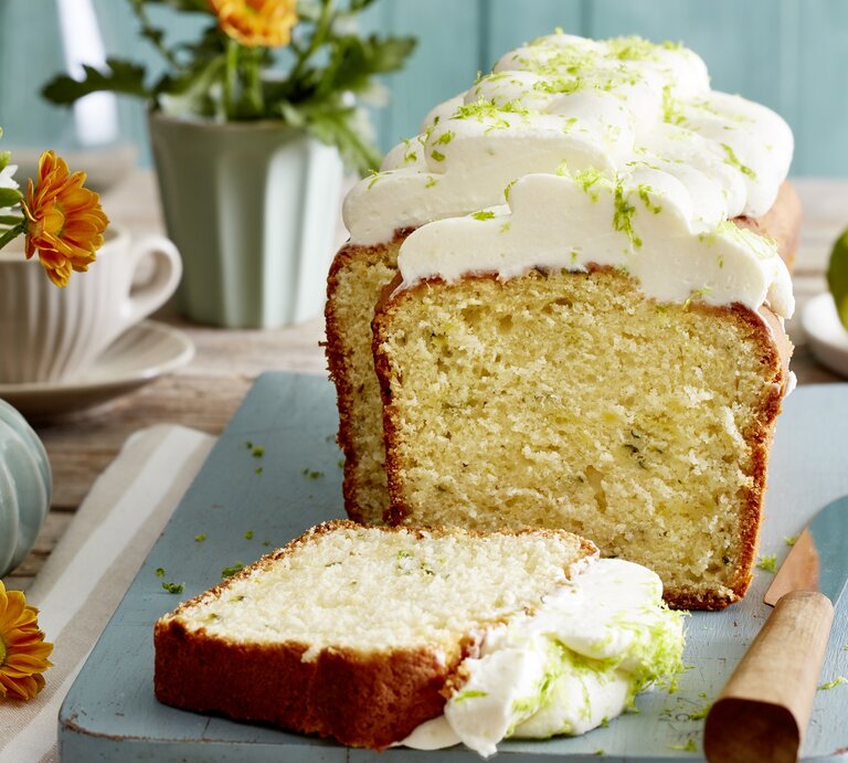 Angeschnittener Limetten-Zucchini-Kuchen auf einem blauen Teller.  | © EAT CLUB/Isabell Triemer