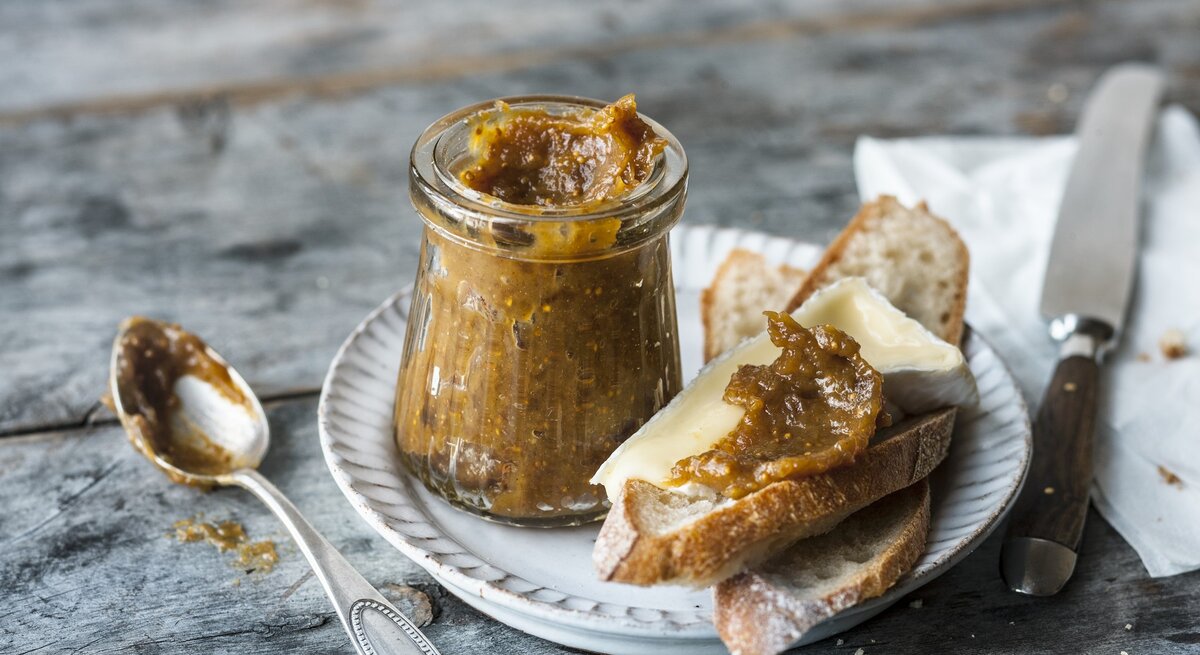 Ein Teller, darauf zwei Scheiben Brot und ein Glas Feigen-Senf-Soße