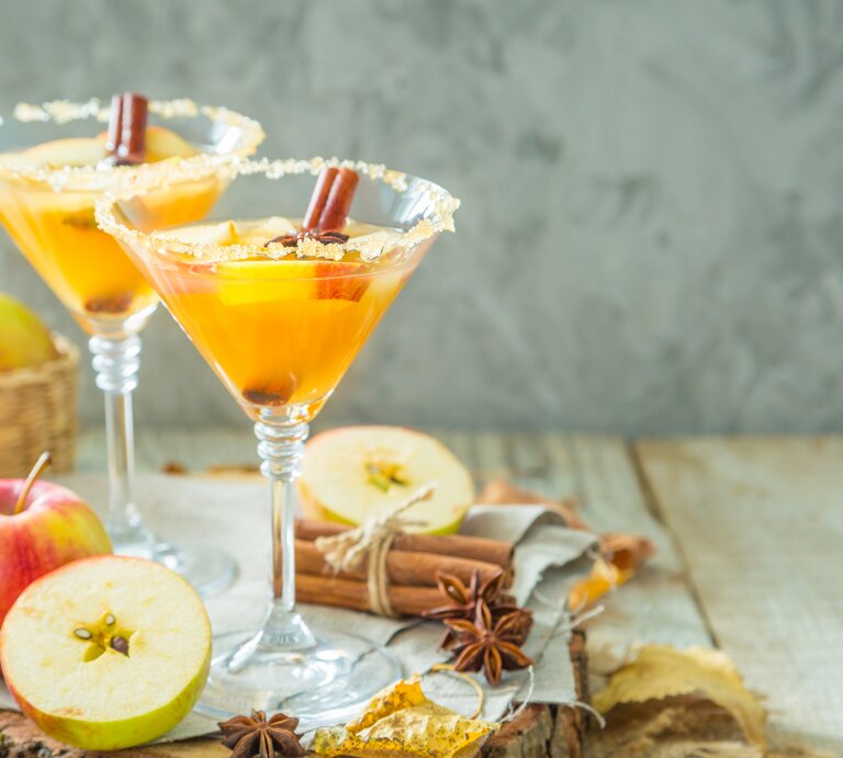 Zwei Martini-Gläser mit dem Getränk auf einem hellen Holztisch von vorne fotografiert. | © Getty Images/ a_namenko