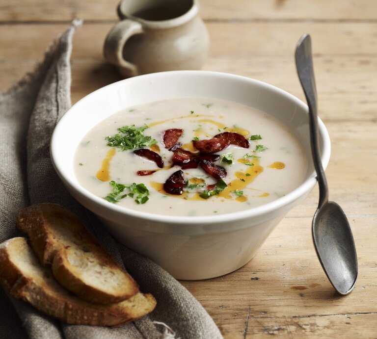 Draufsicht: Eine Schüssel mit einer Bohnensuppe, die mit Wurstscheiben zubereitet wird. | © Stockfood/Bauer Syndication