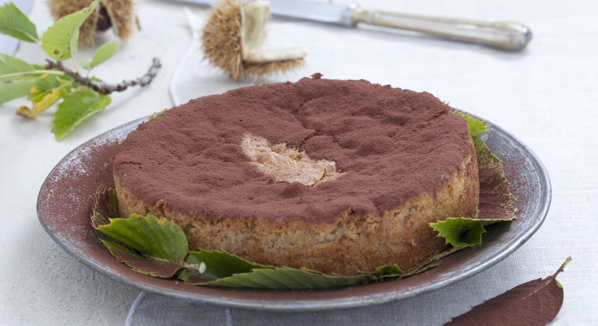 Schräge Draufsicht auf den italienischen Maronenkuchen, der auf einem Tisch steht.