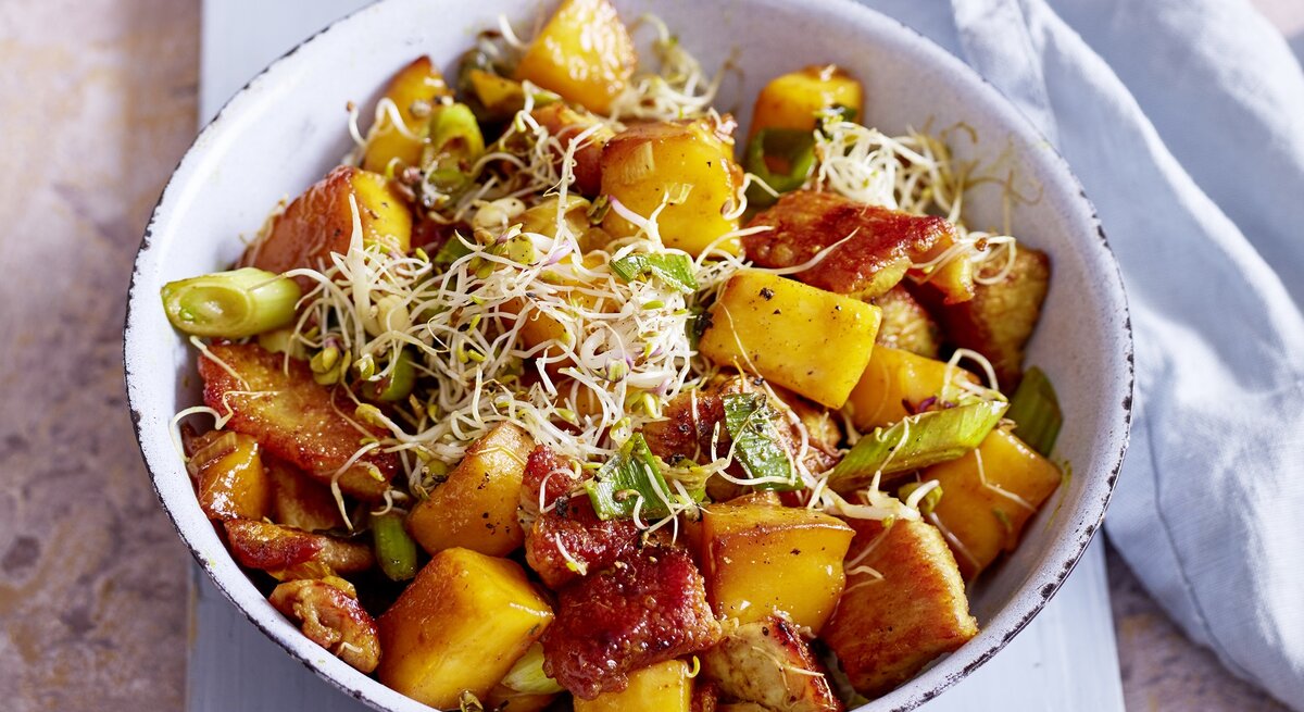 Runde Schüssel / Puten-Pfanne mit Mango, Lauchzwiebeln und Sprossen / Draufsicht / schräg