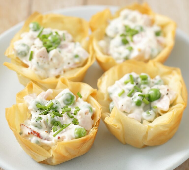 Vier Filoteig mit Schinken, Erbsen und Mayonnaise gefüllt und mit Schnittlauch bestreut / Draufsicht, schräg | © StockFood / Castilho, Rua