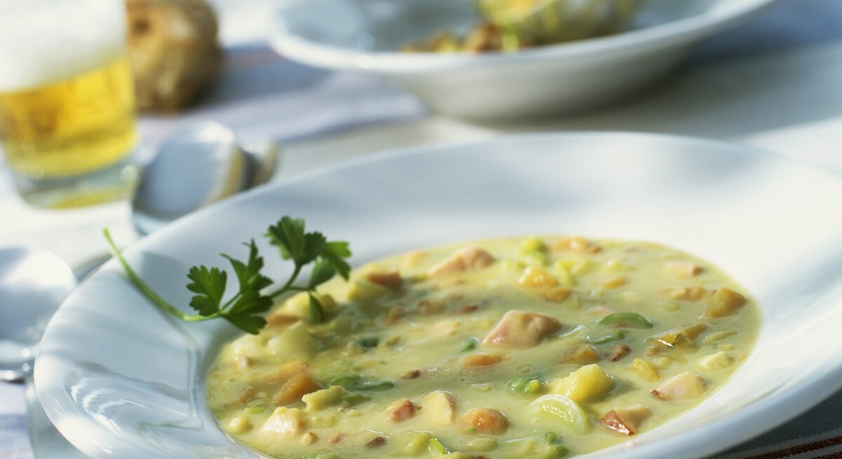altmodischer Teller gefüllt mit >Erbsensuppe und Würstchen. 