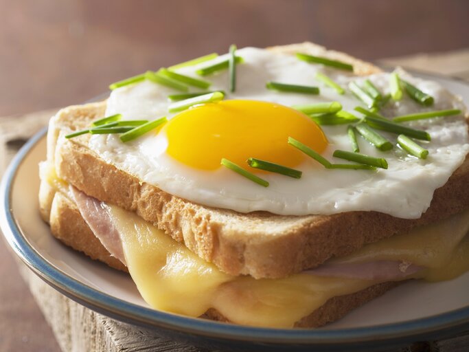 Das Sandwich mit Spiegelei und Schnittlauch belegt in Nahaufnahme direkt von vorne fotografiert. | © StockFood / Miltsova, Olga