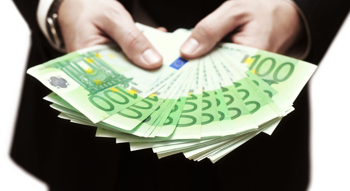 Zwei Hände voller Geld werden in die Kamera gehalten
