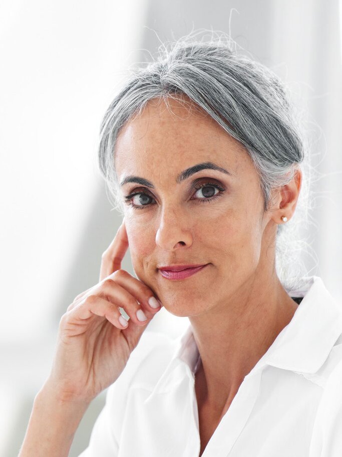 Schöne Frau mit grauen Haaren, die sie nach oben gesteckt hat.  | © iStock/lisegagne 