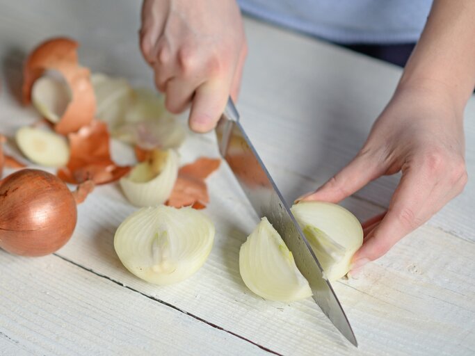 Frau schneidet Zwiebeln | © iStock/MalyDesigner
