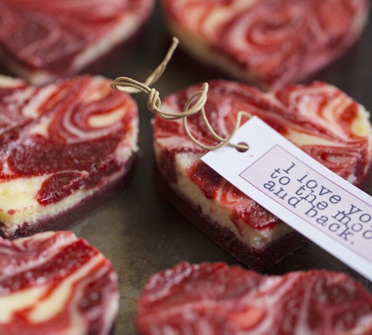 Kleine, herzig ausgestochene Marmorierte Mini-Käsekuchen mit einem rot-weißen Muster auf einer Servierplatte. | © StockFood/Eising Studio