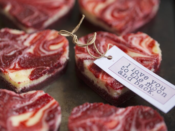 Kleine, herzig ausgestochene Marmorierte Mini-Käsekuchen mit einem rot-weißen Muster auf einer Servierplatte. | © StockFood/Eising Studio