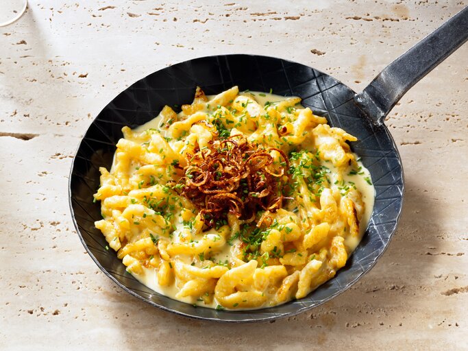 Blick auf eine gusseiserne Pfanne mit Käsespätzle. | © iStock/ JackJelly