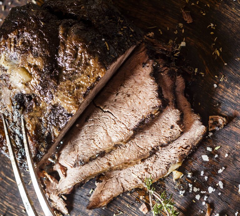 Der angeschnittene Rinderbraten auf einem Holzbrett direkt von oben fotografiert. | © imago/Westend61