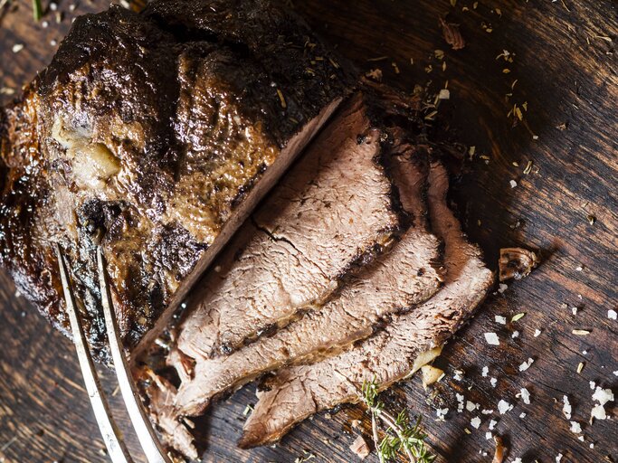 Der angeschnittene Rinderbraten auf einem Holzbrett direkt von oben fotografiert. | © imago/Westend61