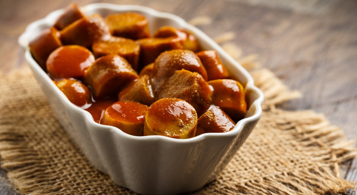 Ein Bild von einem weißen Keramikschale gefüllt mit Berliner Curry-Wurst.